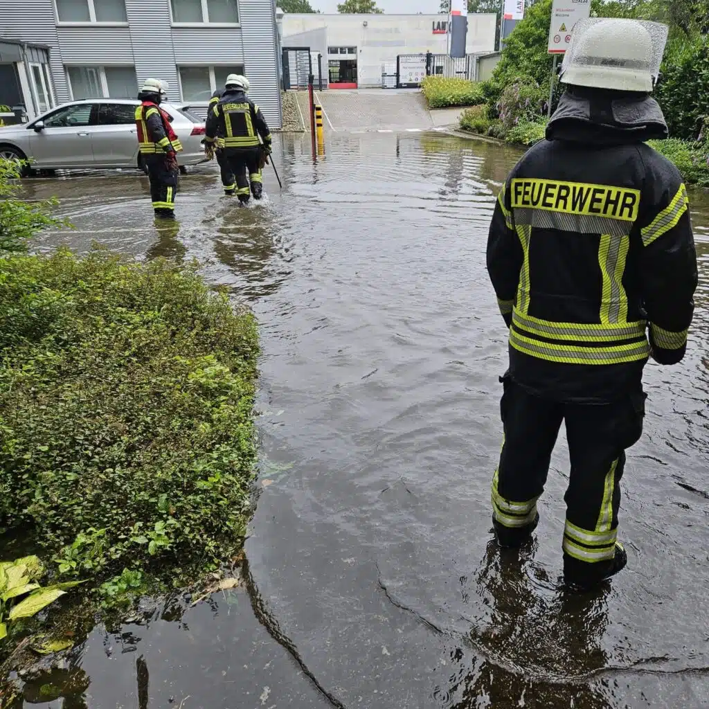 Feuerwehrleute im Wasser auf einem Parkplatz
