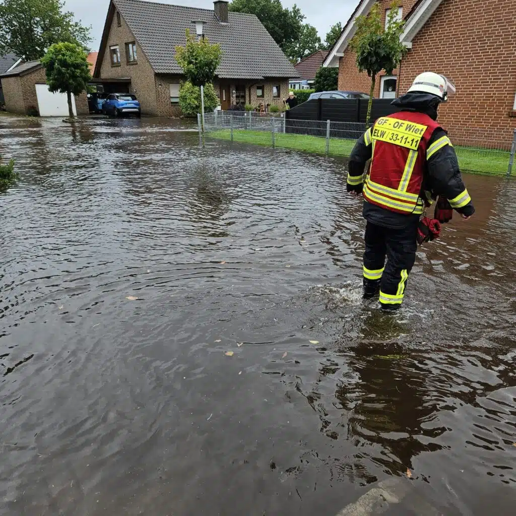 Feuerwehrleute auf überschwemmter Straße