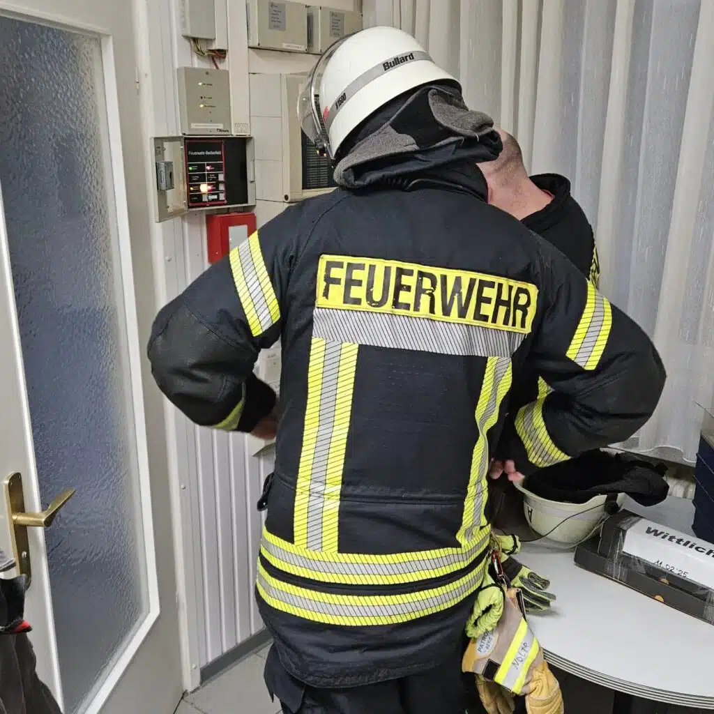 Feuerwehrleute an der Brandmeldeanlage